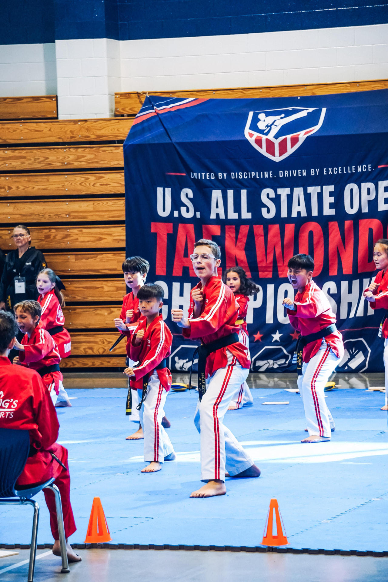 Young competitors performing synchronized kicks at the championship